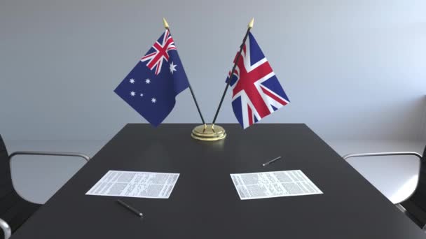 Flaggen Australiens und des vereinigten Königreichs und Papiere auf dem Tisch. Verhandlungen und die Unterzeichnung eines internationalen Abkommens. konzeptionelle 3D-Animation — Stockvideo