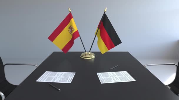Флаги Испании и Германии и бумаги на столе. Переговоры и подписание международного соглашения. Концептуальная 3D анимация — стоковое видео