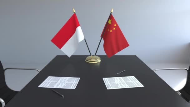 Bandiere di Indonesia e Cina e documenti sul tavolo. Negoziati e firma di un accordo internazionale. Animazione 3D concettuale — Video Stock