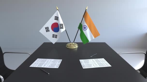 Flaggen Südkoreas und Indiens und Papiere auf dem Tisch. Verhandlungen und die Unterzeichnung eines internationalen Abkommens. konzeptionelle 3D-Animation — Stockvideo