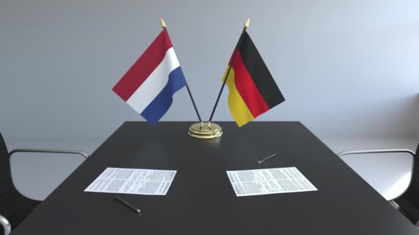Σημαίες των κάτω χωρών και Γερμανίας και χαρτιά στο τραπέζι. Οι διαπραγματεύσεις και η υπογραφή μιας διεθνούς συμφωνίας. Εννοιολογική 3d animation — Αρχείο Βίντεο