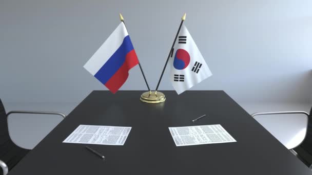 Flaggen Russlands und Südkoreas und Papiere auf dem Tisch. Verhandlungen und die Unterzeichnung eines internationalen Abkommens. konzeptionelle 3D-Animation — Stockvideo