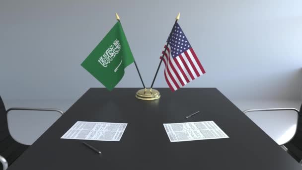 Banderas de Arabia Saudita y los Estados Unidos de América y documentos sobre la mesa. Negociaciones y firma de un acuerdo internacional. Animación 3D conceptual — Vídeos de Stock