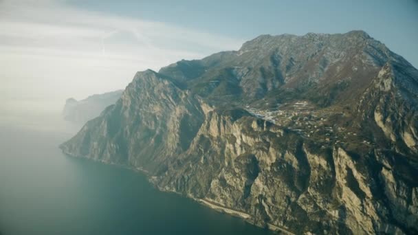 Flygfoto över bergiga stranden av Gardasjön på en disig dag, Italien — Stockvideo