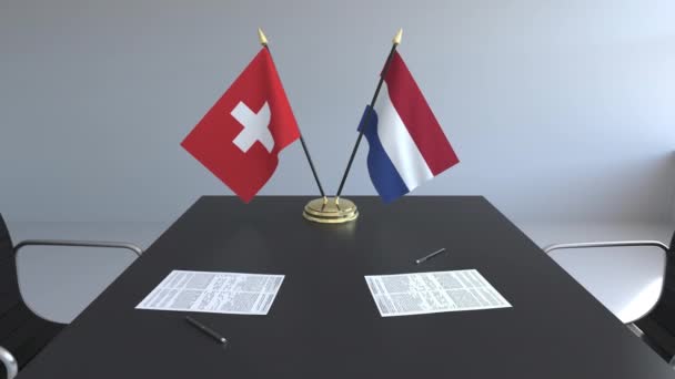 Flaggen der Schweiz und der Niederlande und Papiere auf dem Tisch. Verhandlungen und die Unterzeichnung eines internationalen Abkommens. konzeptionelle 3D-Animation — Stockvideo
