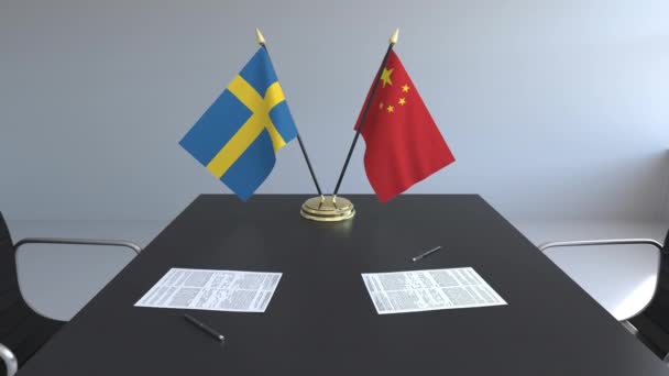 Schweden- und Porzellanfahnen und Papiere auf dem Tisch. Verhandlungen und die Unterzeichnung eines internationalen Abkommens. konzeptionelle 3D-Animation — Stockvideo