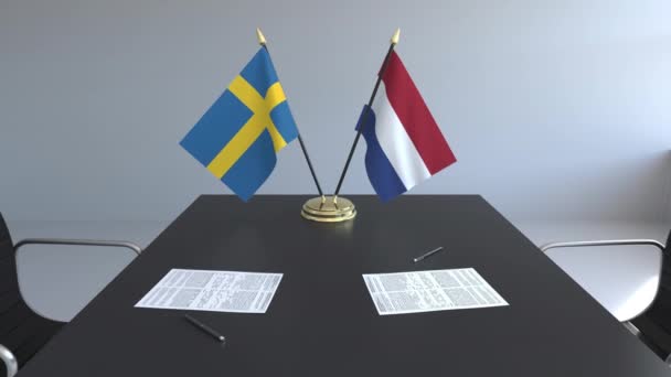 Lijst van vlaggen van Zweden en Nederland en papieren op de tafel. Onderhandelingen en ondertekening van een internationale overeenkomst. Conceptuele 3d animatie — Stockvideo