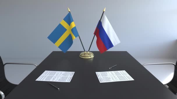 Flaggen Schwedens und Russlands und Papiere auf dem Tisch. Verhandlungen und die Unterzeichnung eines internationalen Abkommens. konzeptionelle 3D-Animation — Stockvideo