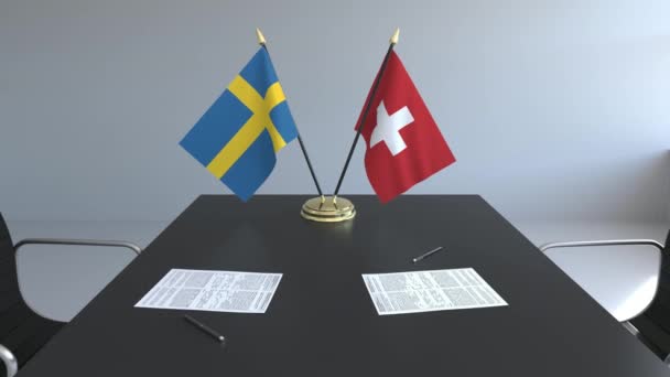 Bandiere di Svezia e Svizzera e carte sul tavolo. Negoziati e firma di un accordo internazionale. Animazione 3D concettuale — Video Stock