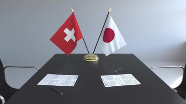 Flaggen der Schweiz und Japans und Papiere auf dem Tisch. Verhandlungen und die Unterzeichnung eines internationalen Abkommens. konzeptionelle 3D-Animation — Stockvideo