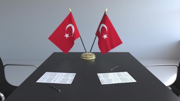 Флаги Турции и бумаги на столе. Переговоры и подписание соглашения. Концептуальная 3D анимация — стоковое видео