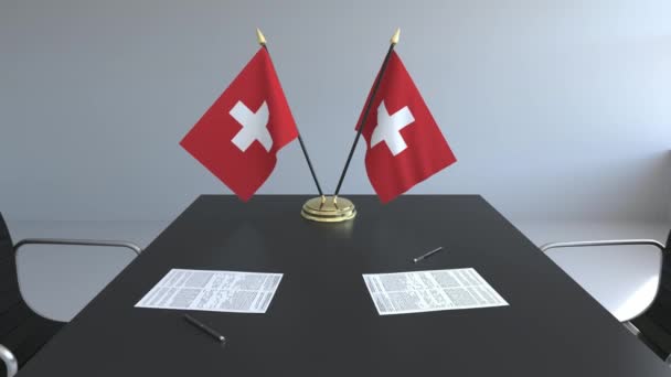 Flags of Switzerland and papers on the table. Negotiations and signing an agreement. Conceptual 3D animation — Stock Video