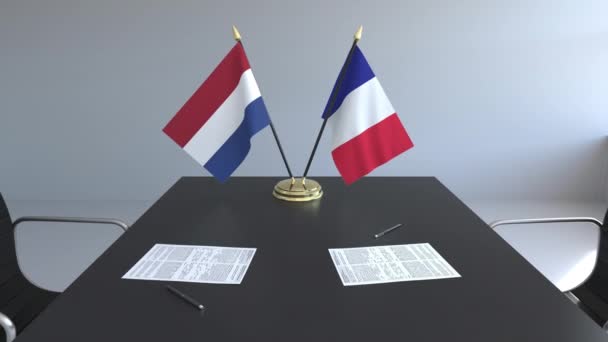 Lijst van vlaggen van Nederland en Frankrijk en papieren op de tafel. Onderhandelingen en ondertekening van een internationale overeenkomst. Conceptuele 3d animatie — Stockvideo
