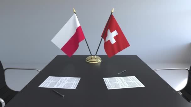 Флаги Польши и Швейцарии и бумаги на столе. Переговоры и подписание международного соглашения. Концептуальная 3D анимация — стоковое видео