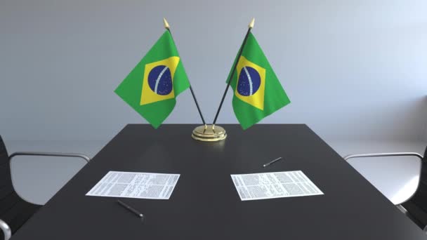 Прапори Бразилії і документи на столі. Переговорів і підписання договору. Концептуальні 3d анімація — стокове відео