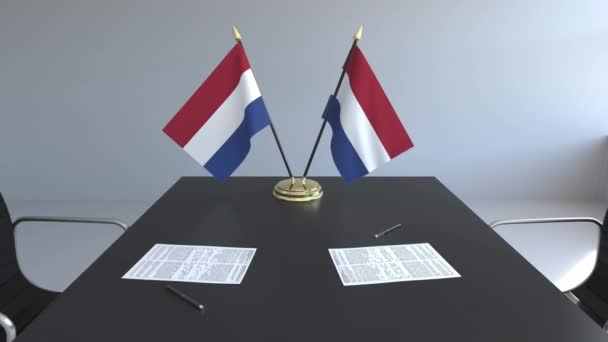 Σημαίες της Ολλανδίας και χαρτιά στο τραπέζι. Οι διαπραγματεύσεις και η υπογραφή μιας συμφωνίας. Εννοιολογική 3d animation — Αρχείο Βίντεο