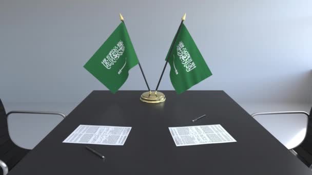 Bandiere dell'Arabia Saudita e documenti sul tavolo. Negoziati e firma di un accordo. Animazione 3D concettuale — Video Stock