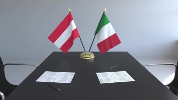Флаги Австрии и Италии и бумаги на столе. Переговоры и подписание международного соглашения. Концептуальная 3D анимация — стоковое видео