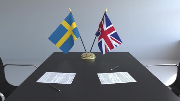 Flaggen Schwedens und des vereinigten Königreichs und Papiere auf dem Tisch. Verhandlungen und die Unterzeichnung eines internationalen Abkommens. konzeptionelle 3D-Animation — Stockvideo