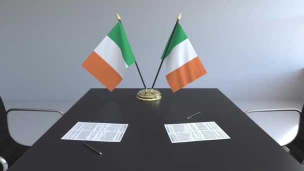 Флаги Ирландии и бумаги на столе. Переговоры и подписание соглашения. Концептуальная 3D анимация — стоковое видео
