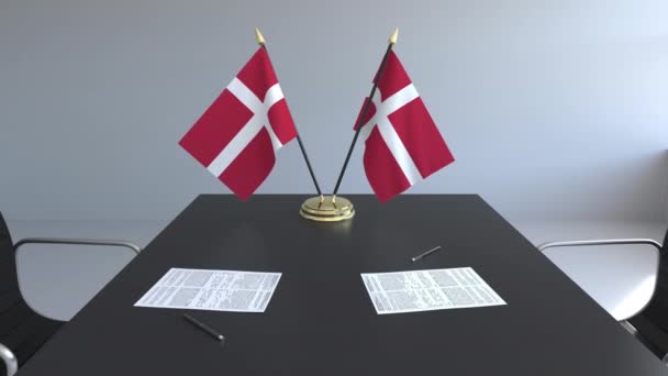 Flaggen von Dänemark und Papiere auf dem Tisch. Verhandlungen und Unterzeichnung eines Abkommens. konzeptionelle 3D-Animation — Stockvideo