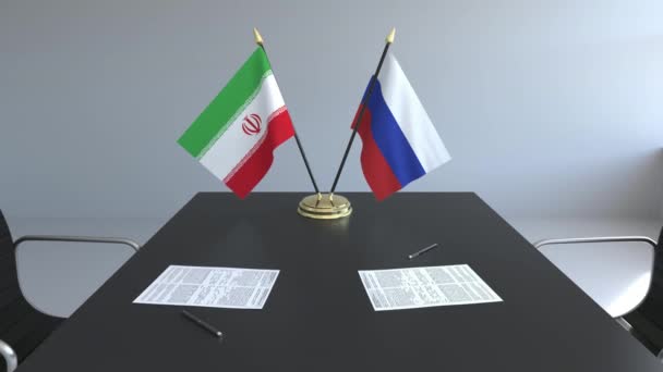 Lijst van vlaggen van Iran en Rusland en papieren op de tafel. Onderhandelingen en ondertekening van een internationale overeenkomst. Conceptuele 3d animatie — Stockvideo