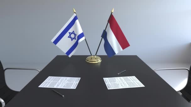 İsrail ve Hollanda ve kağıtları masaya bayrakları. Müzakereler ve uluslararası bir anlaşma imzalama. Kavramsal 3d animasyon — Stok video