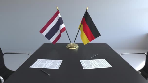 Banderas de Tailandia y Alemania y papeles sobre la mesa. Negociaciones y firma de un acuerdo internacional. Animación 3D conceptual — Vídeo de stock