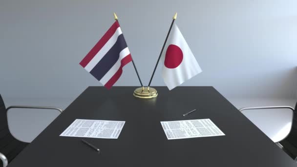 Tayland ve Japonya ve kağıtları masaya bayrakları. Müzakereler ve uluslararası bir anlaşma imzalama. Kavramsal 3d animasyon — Stok video