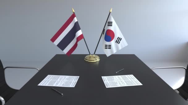 Banderas de Tailandia y Corea del Sur y papeles sobre la mesa. Negociaciones y firma de un acuerdo internacional. Animación 3D conceptual — Vídeos de Stock