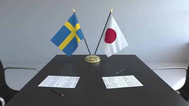Banderas de Suecia y Japón y papeles sobre la mesa. Negociaciones y firma de un acuerdo internacional. Animación 3D conceptual — Vídeo de stock