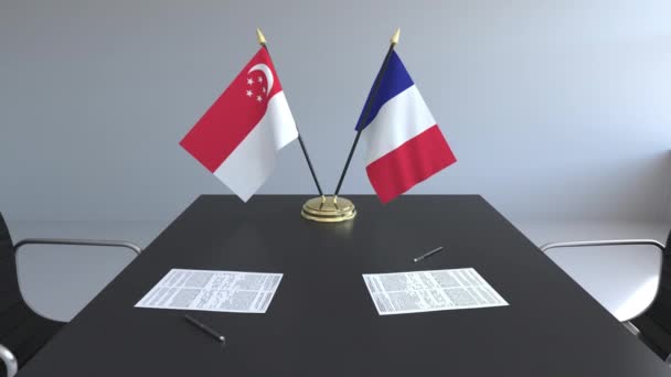 Flaggen von Singapore und Frankreich und Papiere auf dem Tisch. Verhandlungen und die Unterzeichnung eines internationalen Abkommens. konzeptionelle 3D-Animation — Stockvideo