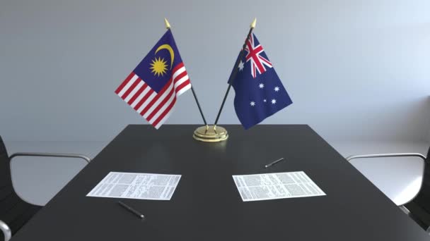 Flaggen von Malaysia und Australien und Papiere auf dem Tisch. Verhandlungen und die Unterzeichnung eines internationalen Abkommens. konzeptionelle 3D-Animation — Stockvideo