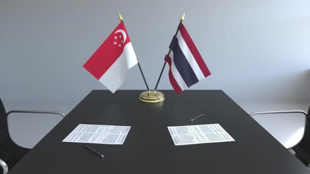 Bandiere di Singapore e Thailandia e carte sul tavolo. Negoziati e firma di un accordo internazionale. Animazione 3D concettuale — Video Stock