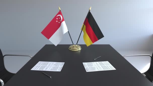 Прапори Сінгапуру та Німеччини і документи на столі. Переговорів і підписання міжнародного договору. Концептуальні 3d анімація — стокове відео