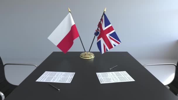 Banderas de Polonia y el Reino Unido y documentos sobre la mesa. Negociaciones y firma de un acuerdo internacional. Animación 3D conceptual — Vídeos de Stock