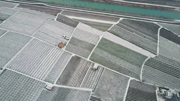 Lanzamiento aéreo de campos cubiertos de nieve y granjas en el norte de Italia — Foto de Stock