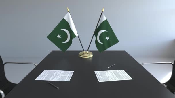 Flaggen Pakistans und Papiere auf dem Tisch. Verhandlungen und Unterzeichnung eines Abkommens. konzeptionelle 3D-Animation — Stockvideo
