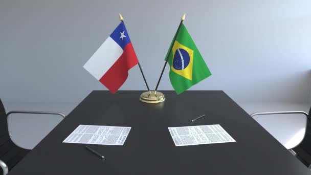Флаги Чили и Бразилии и бумаги на столе. Переговоры и подписание международного соглашения. Концептуальная 3D анимация — стоковое видео