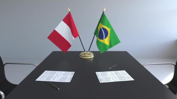 Флаги Перу и Бразилии и бумаги на столе. Переговоры и подписание международного соглашения. Концептуальная 3D анимация — стоковое видео