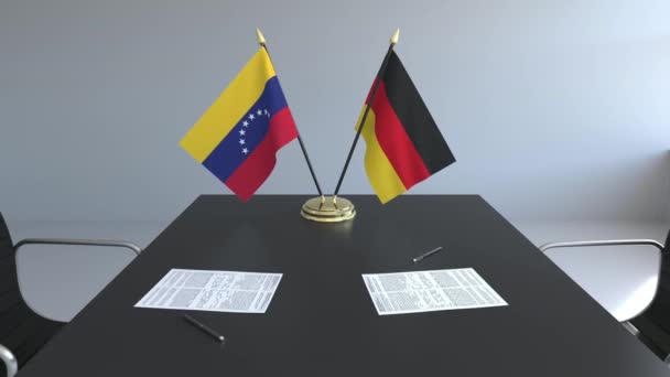 Lijst van vlaggen van Venezuela en Duitsland en papieren op de tafel. Onderhandelingen en ondertekening van een internationale overeenkomst. Conceptuele 3d animatie — Stockvideo