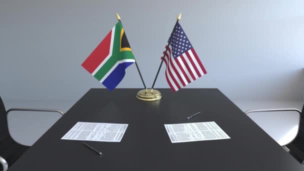 Banderas de Sudáfrica y Estados Unidos y documentos sobre la mesa. Negociaciones y firma de un acuerdo internacional. Animación 3D conceptual — Vídeo de stock