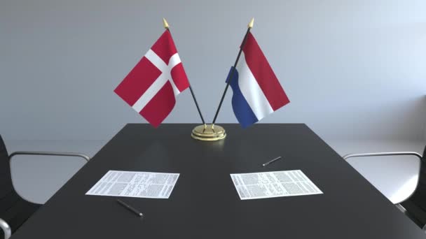 Bandiere della Danimarca e dei Paesi Bassi e documenti sul tavolo. Negoziati e firma di un accordo internazionale. Animazione 3D concettuale — Video Stock