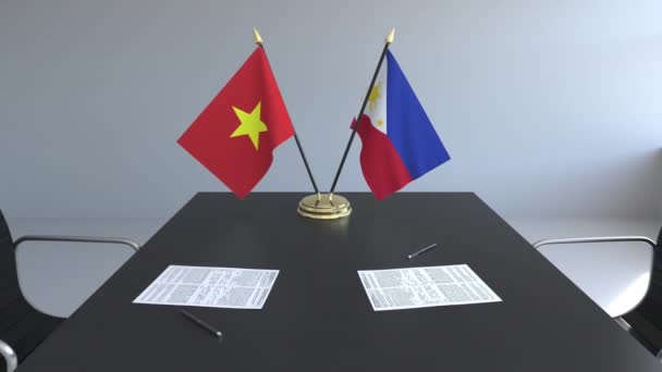 Flaggen Vietnams und der Philippinen und Papiere auf dem Tisch. Verhandlungen und die Unterzeichnung eines internationalen Abkommens. konzeptionelle 3D-Animation — Stockvideo