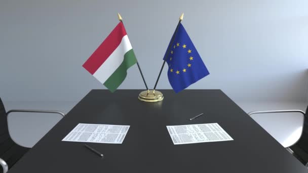Flaggen Ungarns und der Europäischen Union und Papiere auf dem Tisch. Verhandlungen und die Unterzeichnung eines internationalen Abkommens. konzeptionelle 3D-Animation — Stockvideo