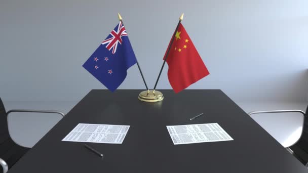 Yeni Zelanda ve Çin ve kağıtları masaya bayrakları. Müzakereler ve uluslararası bir anlaşma imzalama. Kavramsal 3d animasyon — Stok video