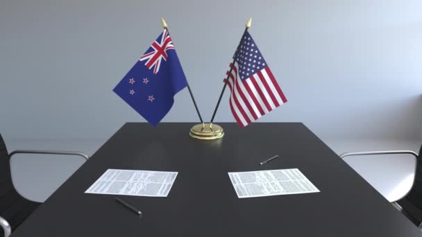 Флаги Новой Зеландии и Соединенных Штатов и бумаги на столе. Переговоры и подписание международного соглашения. Концептуальная 3D анимация — стоковое видео