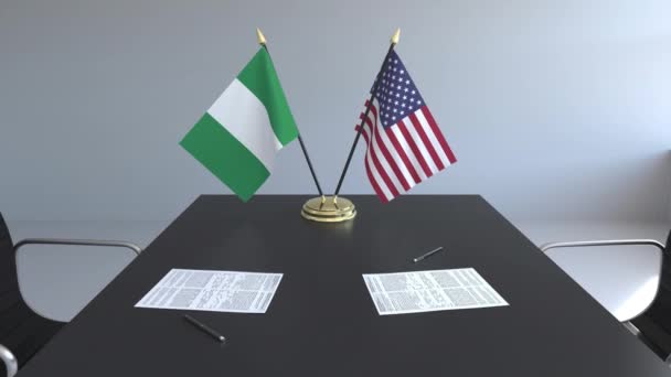 Bandeiras da Nigéria e dos Estados Unidos e documentos sobre a mesa. Negociações e assinatura de um acordo internacional. Animação 3D conceitual — Vídeo de Stock
