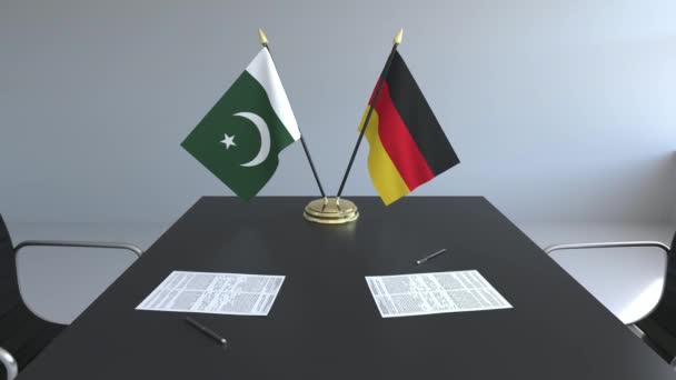 Bandeiras do Paquistão e da Alemanha e papéis na mesa. Negociações e assinatura de um acordo internacional. Animação 3D conceitual — Vídeo de Stock
