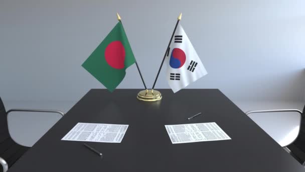 Flaggen aus Bangladesch und Südkorea und Papiere auf dem Tisch. Verhandlungen und die Unterzeichnung eines internationalen Abkommens. konzeptionelle 3D-Animation — Stockvideo